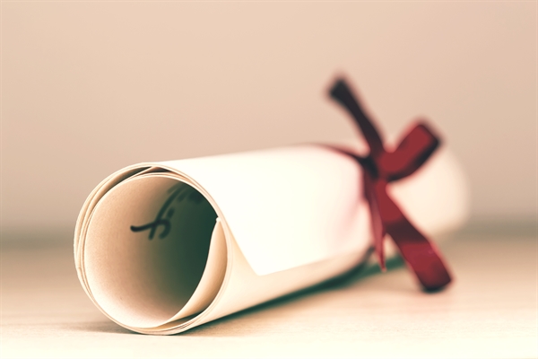 Rolled certificate tied with red ribbon